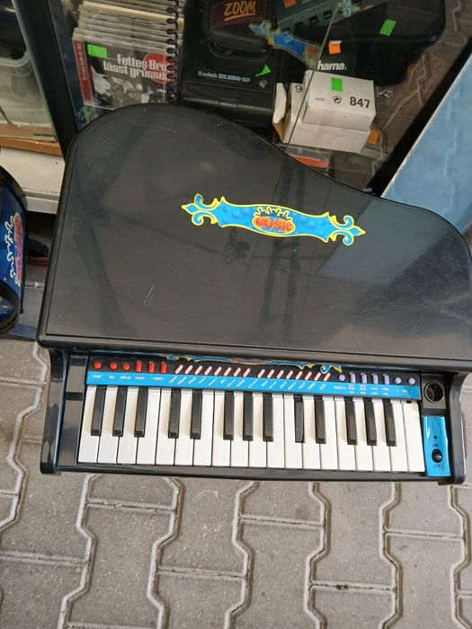 czarne, plastikowe pianino-zabawka w kształcie mini fortepianu