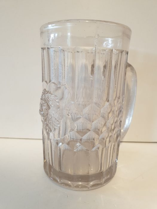 Antiga caneca de cerveja com cabeça de leão em vidro prensado