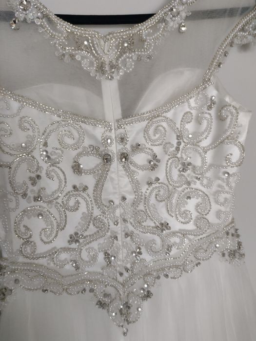 Suknia ślubna bogato zdobiona na lekkim rękawku