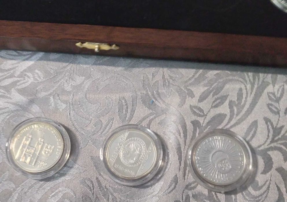 Coleção de sete moedas em pratas, com caixa em madeira