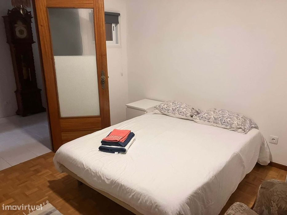 Spacious bedroom with a double bed, a desk and a couch
