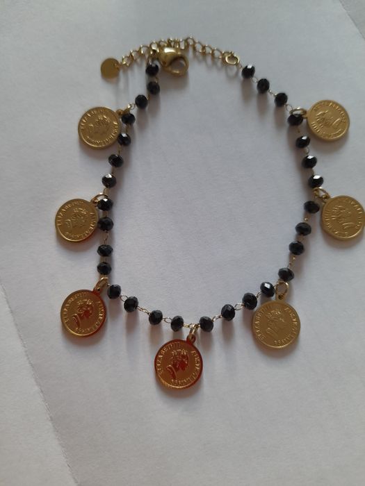 Złota bransoletka z czarnymi koralikami i złotymi przywieszkami