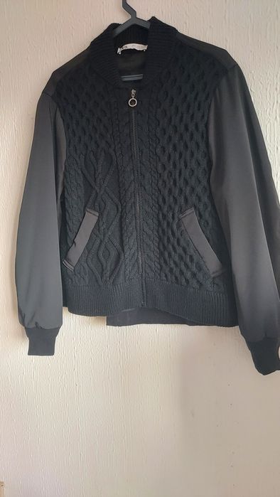 Casaco de malha trabalhada à  frente com bolsos.