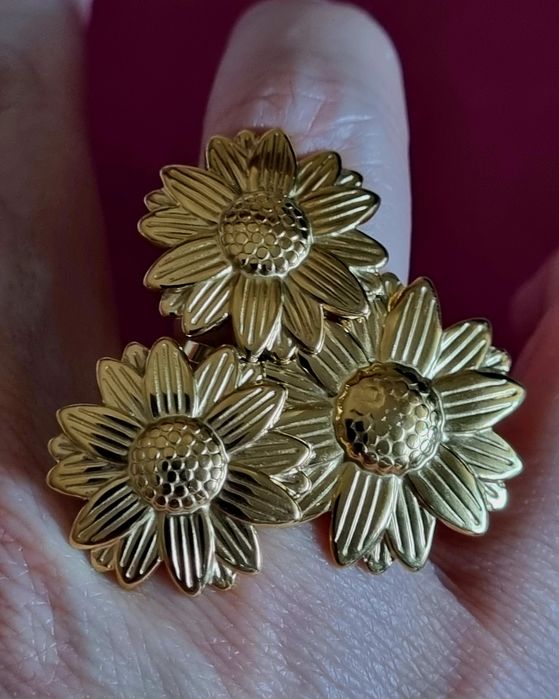 Anel dourado, em aço, formato de 3 lindas flores. Ajustável