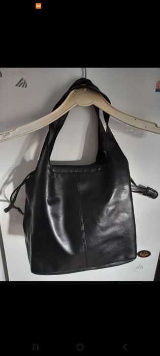 Mala preta, com mola e fios laterais para fechar.