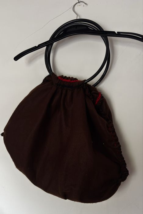 Mala de mão castanha com detalhes vermelhos