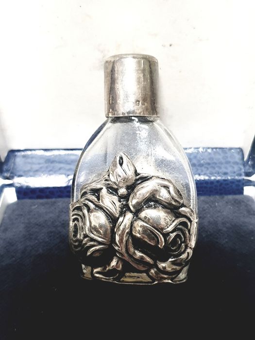 Beautiful vintage perfume bottle with contrasting silver rose motif