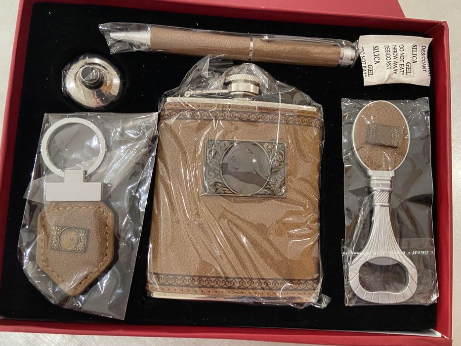 Caixa com caneta, garrafa, abre latas e porta chaves