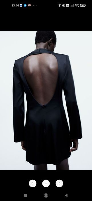 Czarna krótka sukienka z poduszkamin na ramionach i wycięciem z tyłu