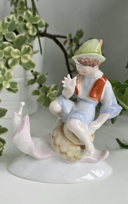USZKODZONA porcelanowa figurka Chłopiec na ślimaku, Hollohaza Węgry