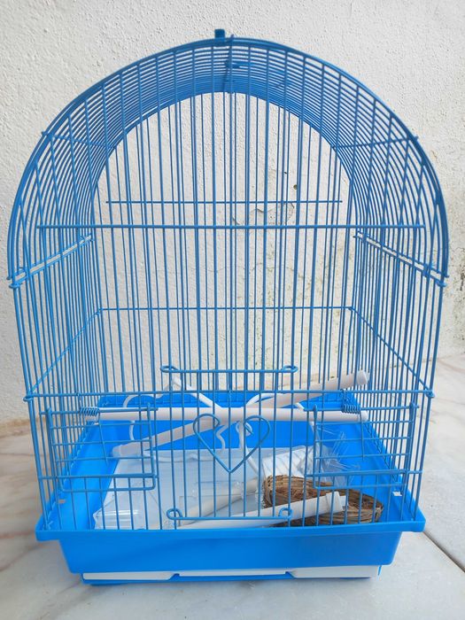 gaiola azul com acessórios para pássaros
