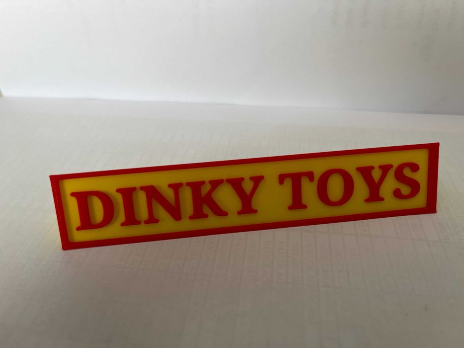 Sinal DINKY TOYS p/expositor miniaturas, paral. triang.reg., amarelo