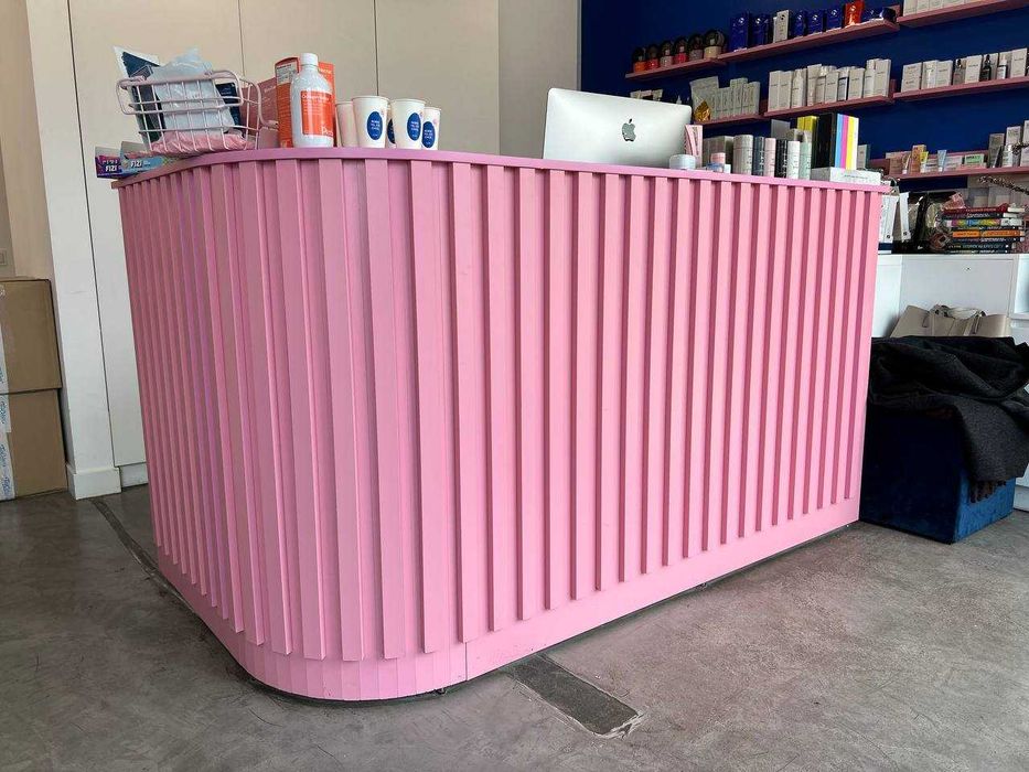 Recepcja różowa z szafkami pod nią