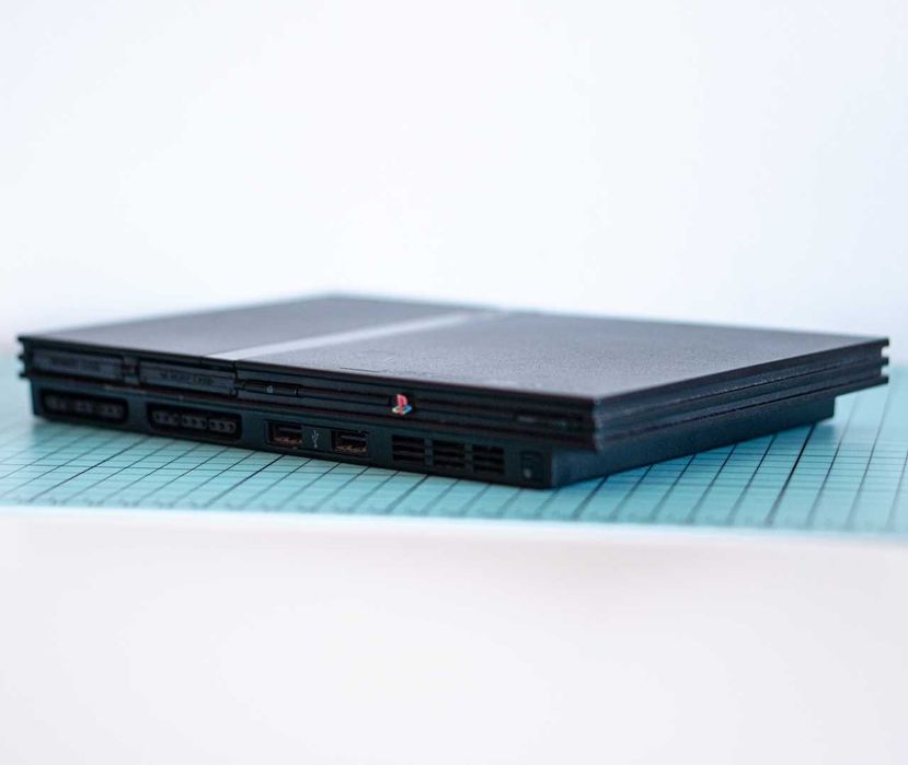 Consola PlayStation 2 Slim + 2 Comandos + 2 Memory Cards + 4 Jogos