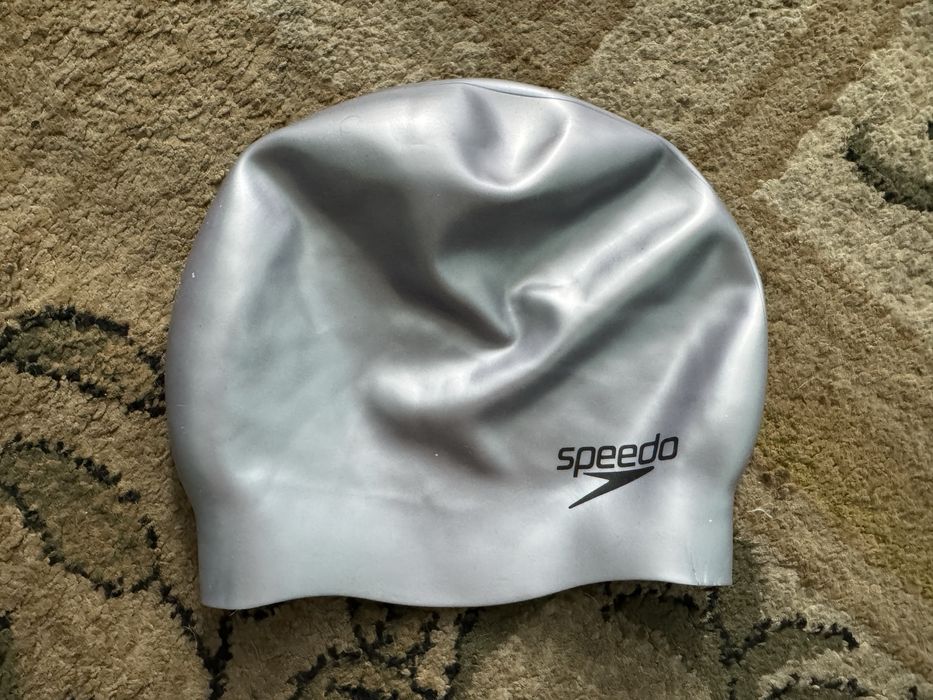 Срібляста силіконова шапочка для плавання бренду Speedo.