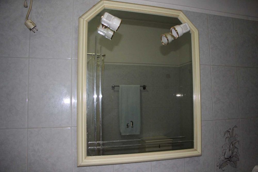 Espelho de casa de banho com dois candeeiros embutidos.