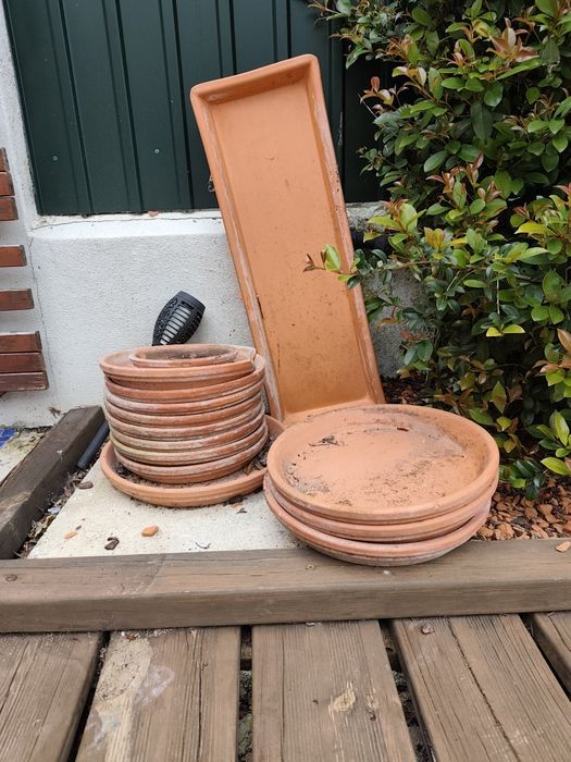 Vários pratos em barro para vasos
