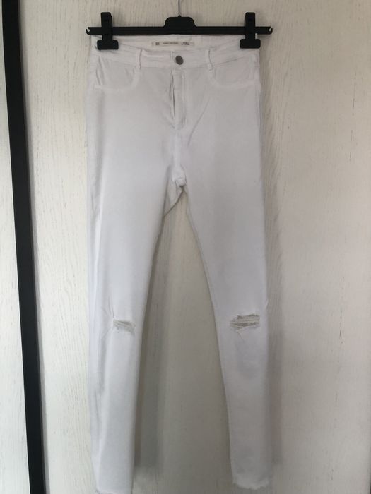Białe spodnie z przetarciami jeans zara