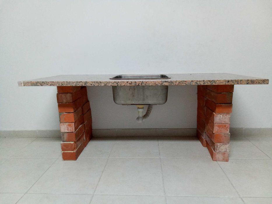 Bancada de pedra mármore com pia de lavar loiça e tijolos burro