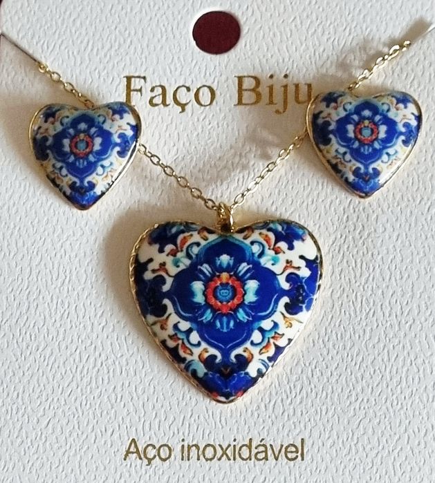 Conjunto dourado, em aço, com corações de Viana em tons de azul.
