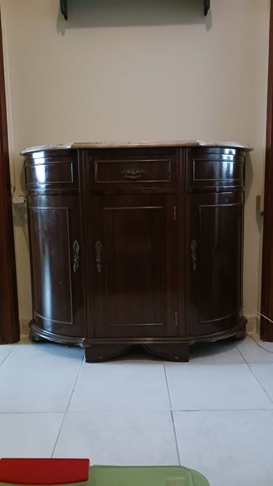 Aparador de madeira escura com tampo de mármore claro