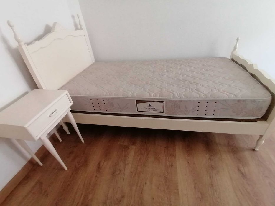 Cama de solteiro, branca, com colchão + mesa de cabeceira.