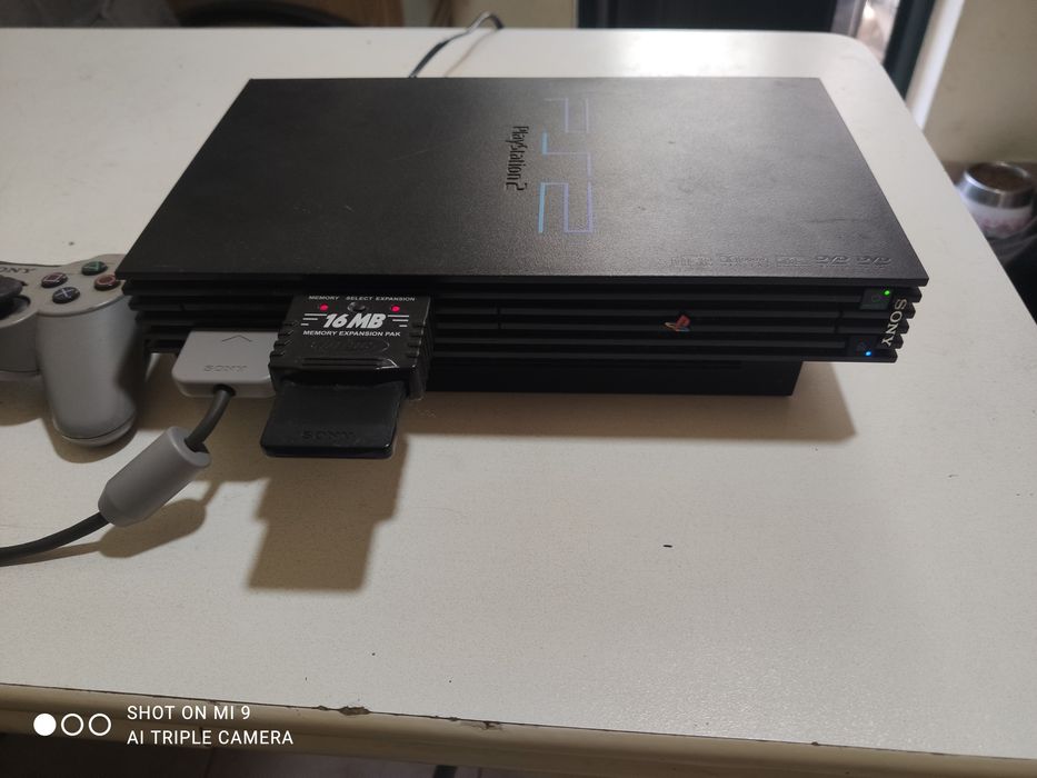 PS2 com comando e um jogo