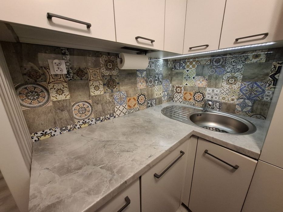 Zabudowa kuchenna ze stołem i sprzętem AGD