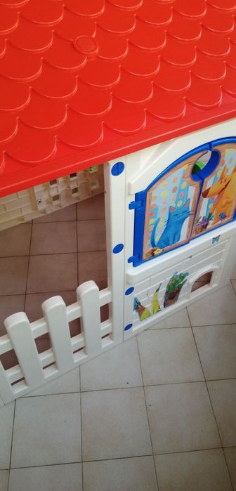Casa de jardim de criança de plástico com telhado vermelho em bom estado