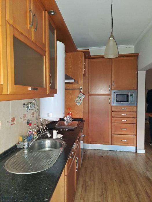 Cozinha completa com tampo em pedra e eletrodomésticos