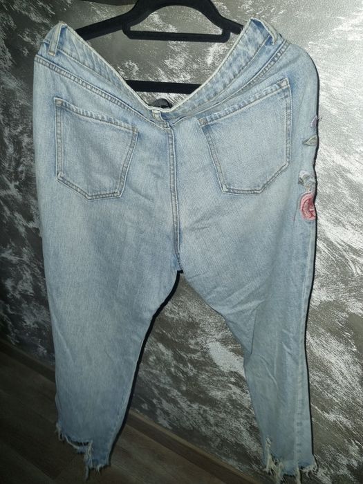 Super dżinsy z rozdarciami haftowanymi kwiatami.