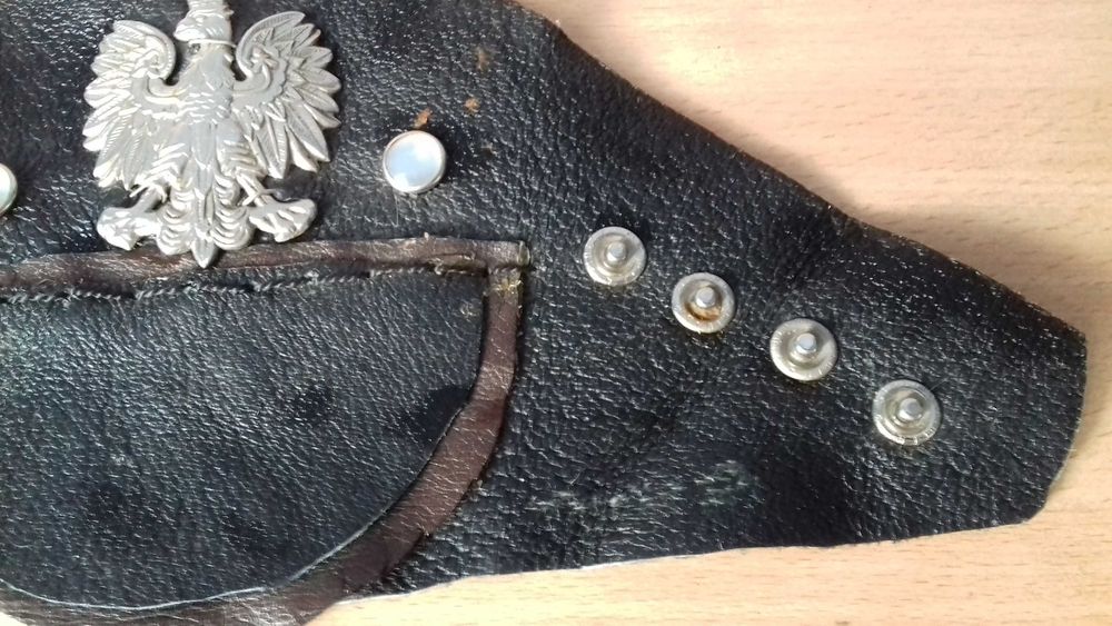 Srebrny orzełek w koronie na skórze.