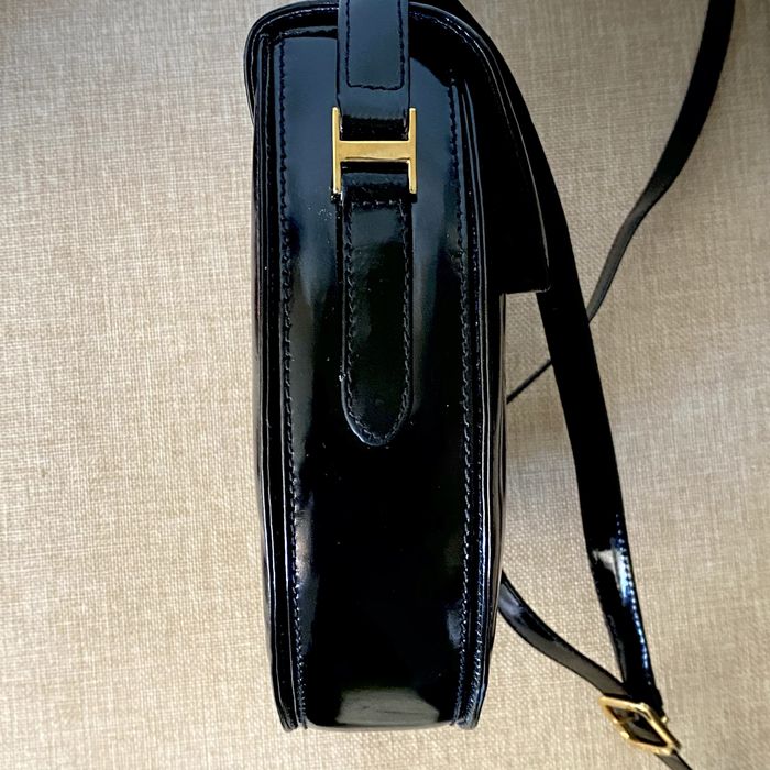 Bolsa em pele, Aries, com acabamento em verniz e fecho magnético.