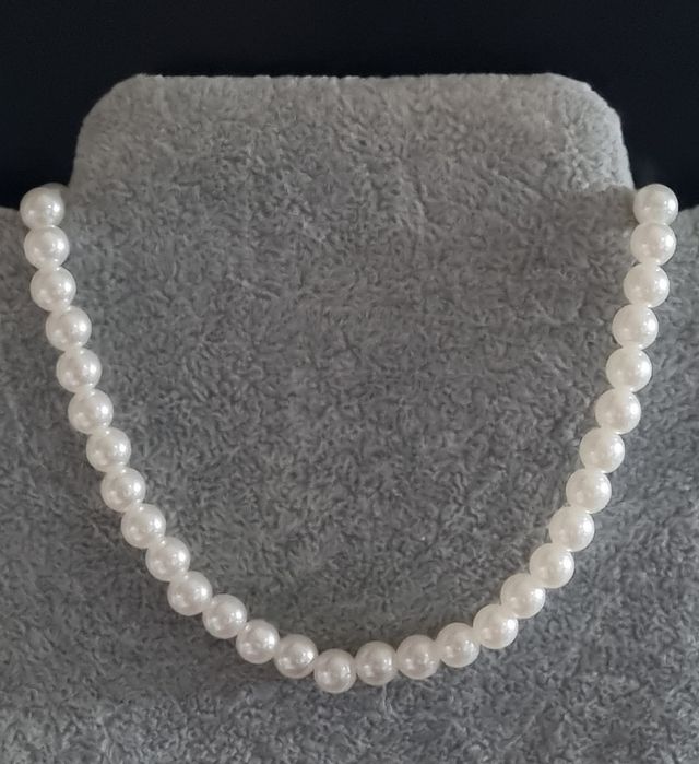 Colar/choker de pérolas com acabamento dourado em açol. Tem extensor