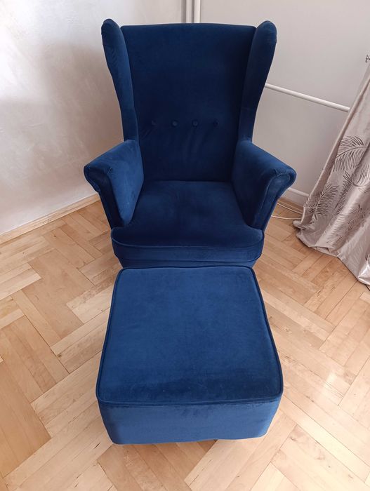 Fotel uszak z podnóżkiem i z narzutką niebieską.