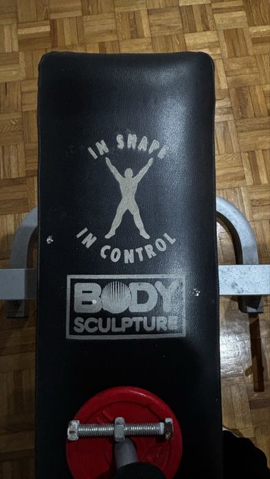 Banco de musculação com suporte para barra + halteres.