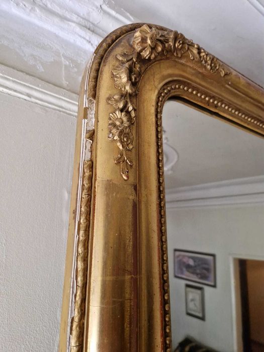 Grande espelho de parede antigo, com uma moldura dourada ornamentada de estilo clássico