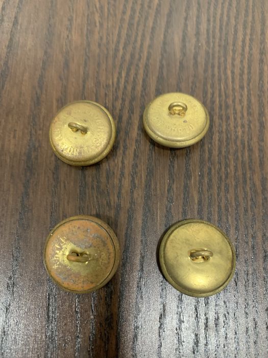 Quatro Botões de fardamento militar.