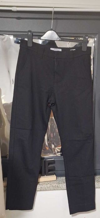 Calças pretas um pouco clássicas e justas ao corpo