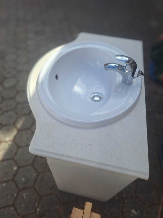 Móvel de casa de banho usado com lavatório em cerâmica e torneira.