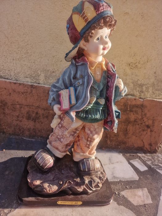Estatueta de um menino estudante