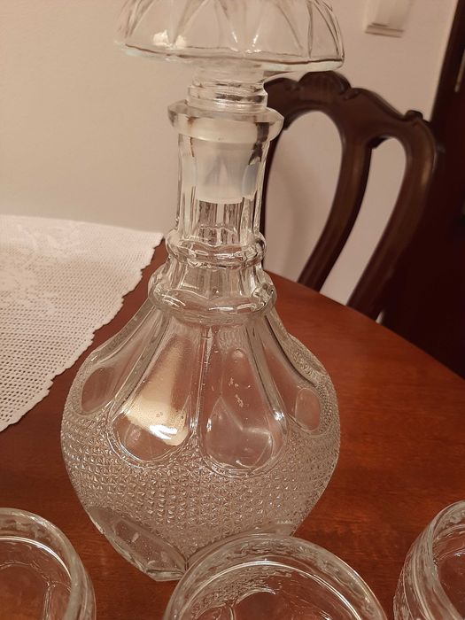 Garrafa antiga de vidro e seis copos