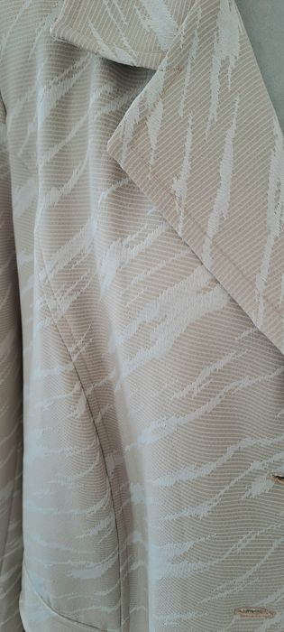 blazer feminino de cor bege com um padrão abstrato claro,