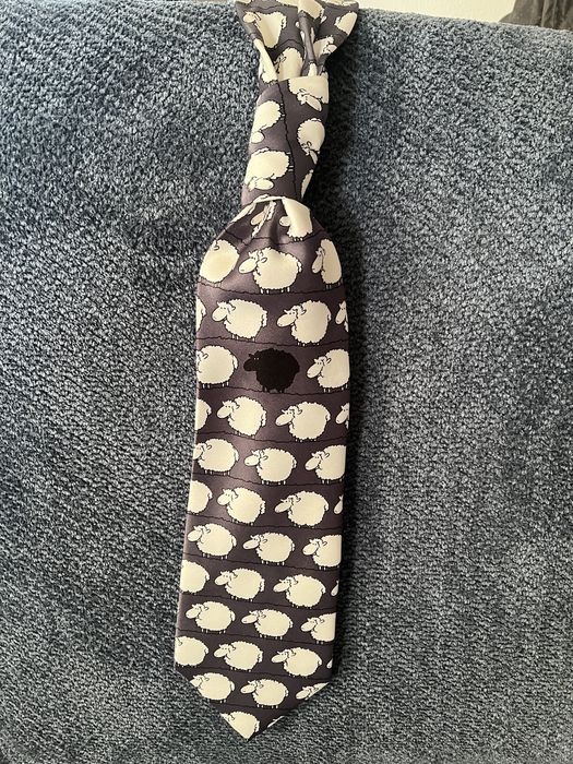 Czarny krawat w białe owce jedna czarna pośrodku. Oryginalny i zabawny