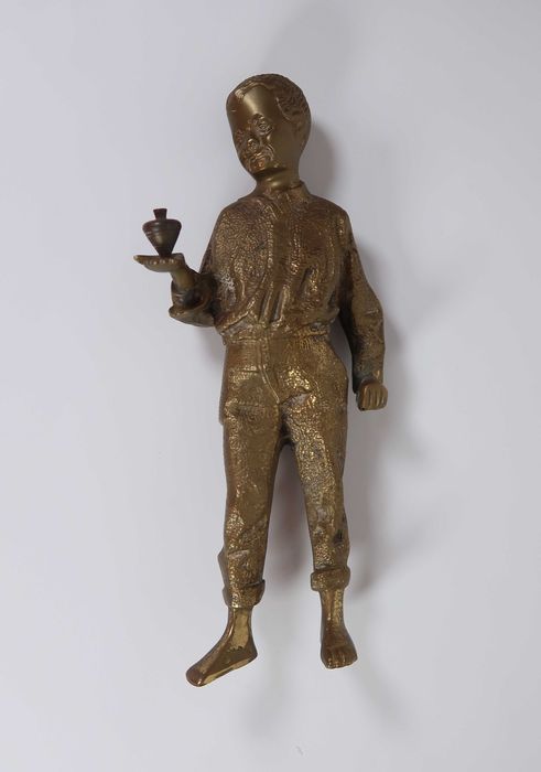 Escultura de menino com peão em bronze