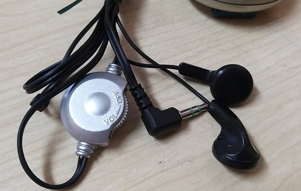 Rádio a pilhas com auscultadores.