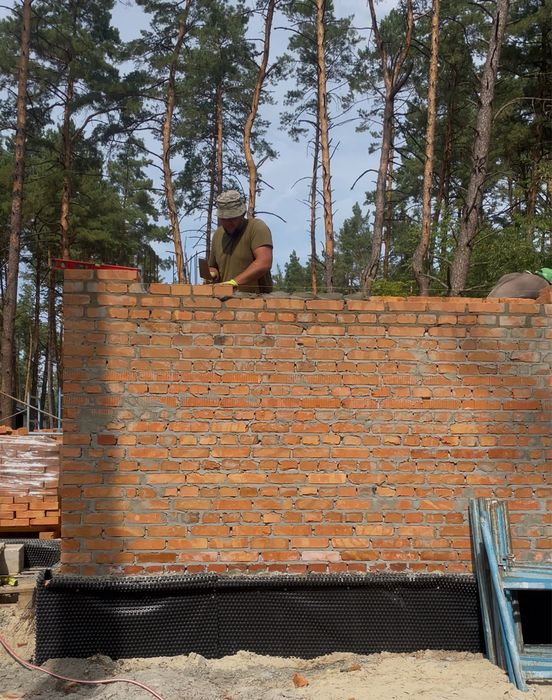Будівництво. Бригада будівельників. Мурування цегли, керамоблоку