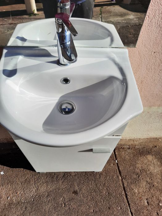 Pequeno móvel com lavatório, torneira e espelho