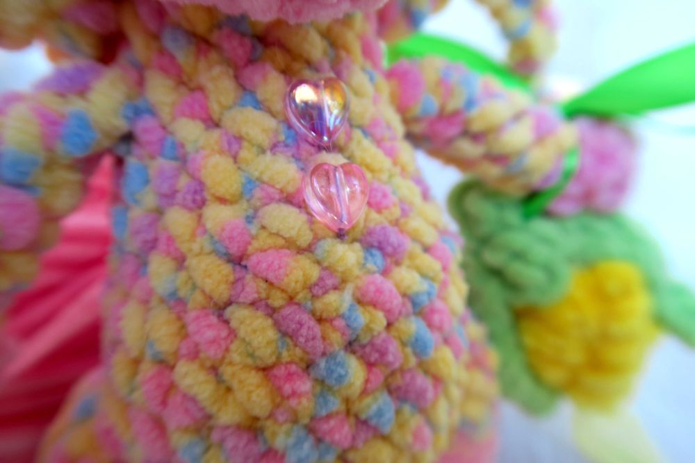 В'язана кольорова свинка в чепчику та з кукурудзою