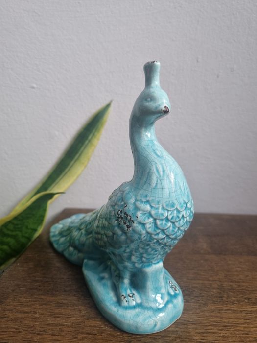 ceramiczna figurka pawia w kolorze turkusowym.